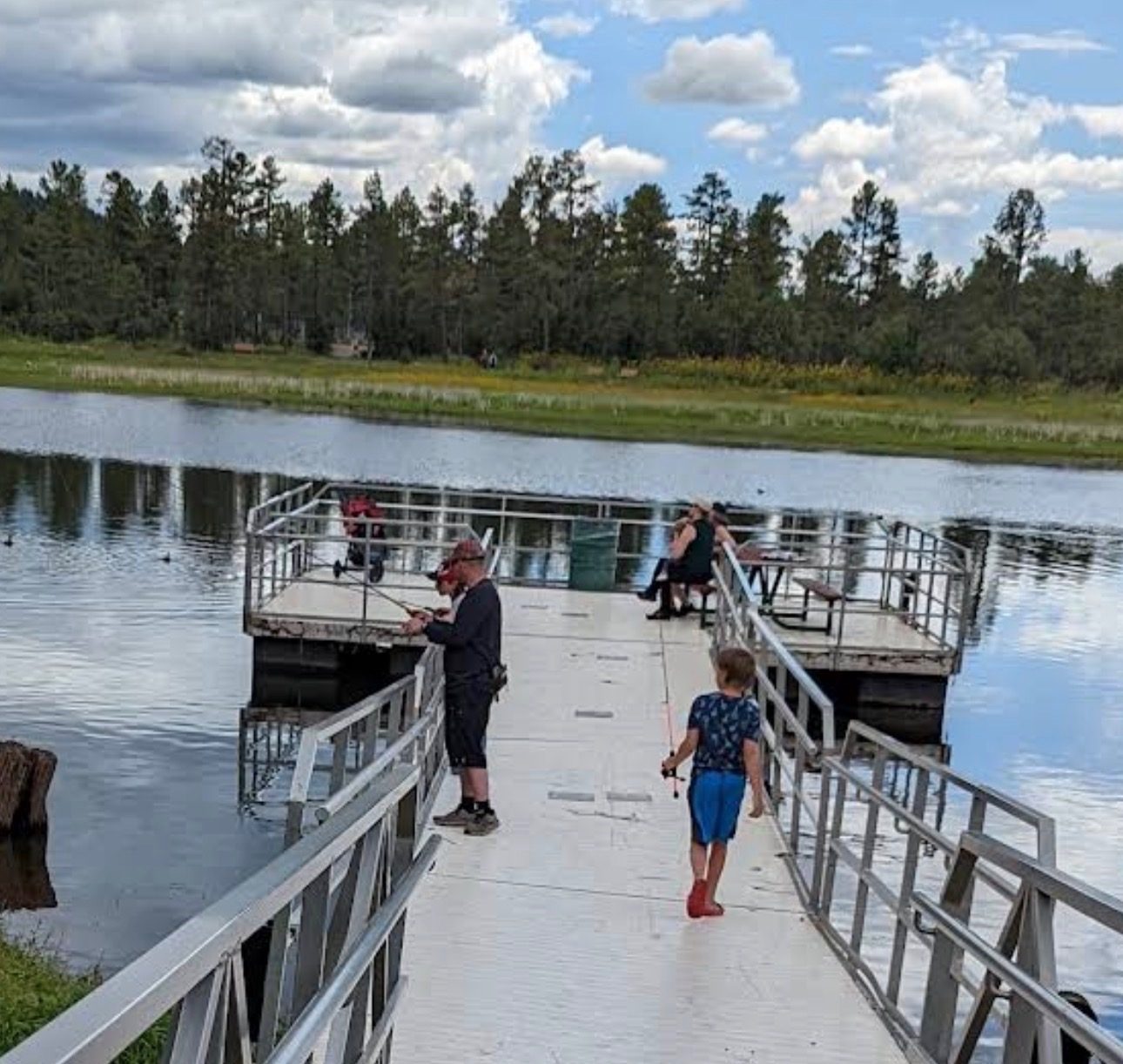 A family fishing from the pier at Woodland Lake Park in Pinetop-Lakeside, Arizona